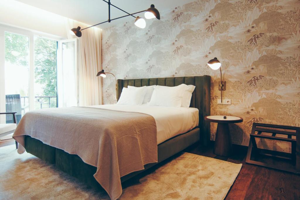 ein Schlafzimmer mit einem großen Bett und einem Fenster in der Unterkunft Estalagem Santa Iria Hotel & Spa in Tomar