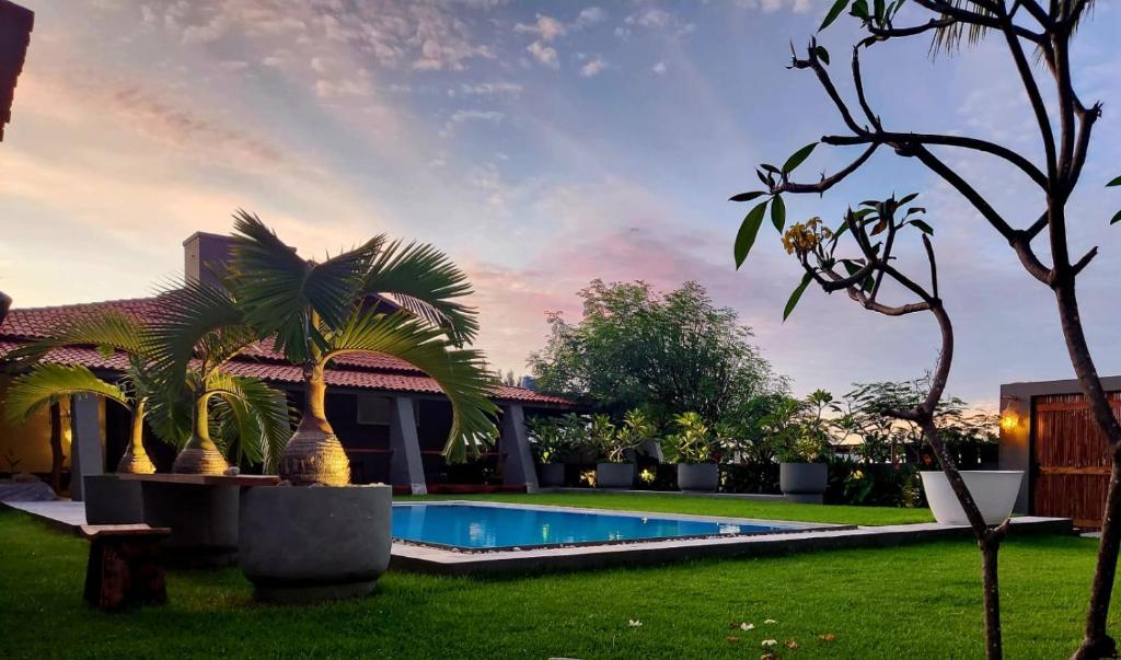 a backyard with a swimming pool and palm trees at Outro Beach Hotel Cumbuco in Cumbuco