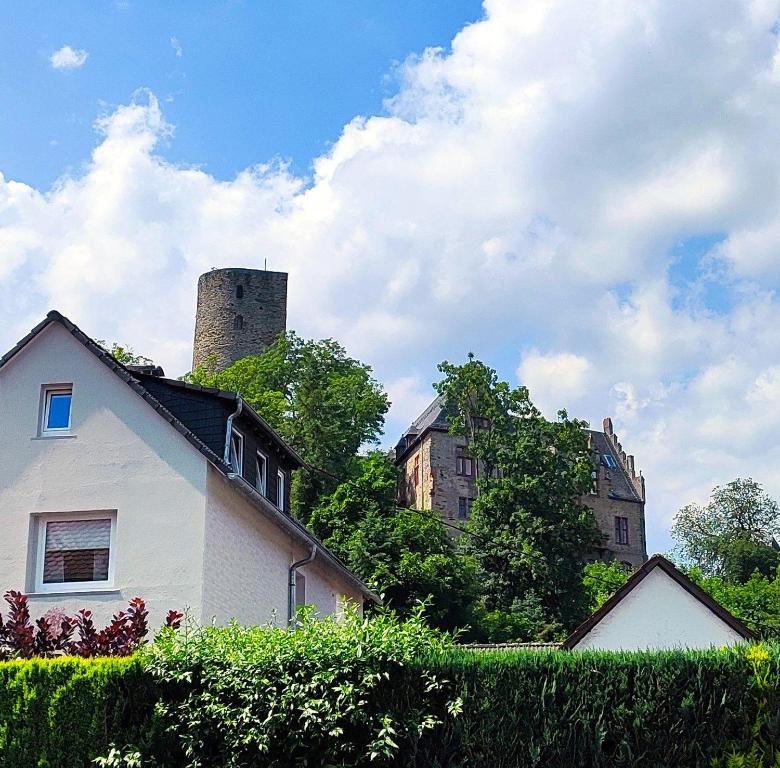 a house with a tower on top of a building at Unterkunft4You-Ferienhaus-Zum-Burgfried in Usingen