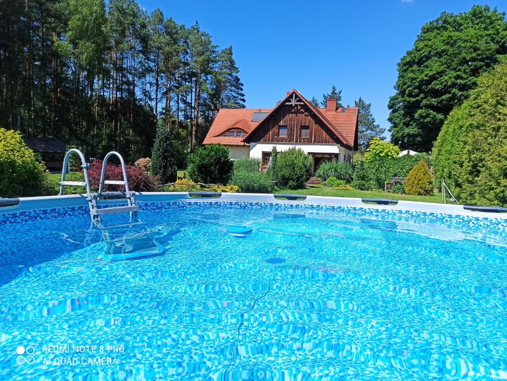 una piscina con una casa sullo sfondo di Pensjonat u Garncarza a Polnica