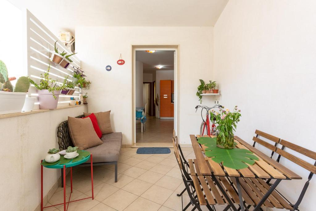 uma sala de estar com uma mesa e um sofá em Scialài em Marina di Ragusa