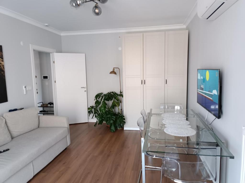 een woonkamer met een witte bank en een glazen tafel bij BAOF residence in Istanbul
