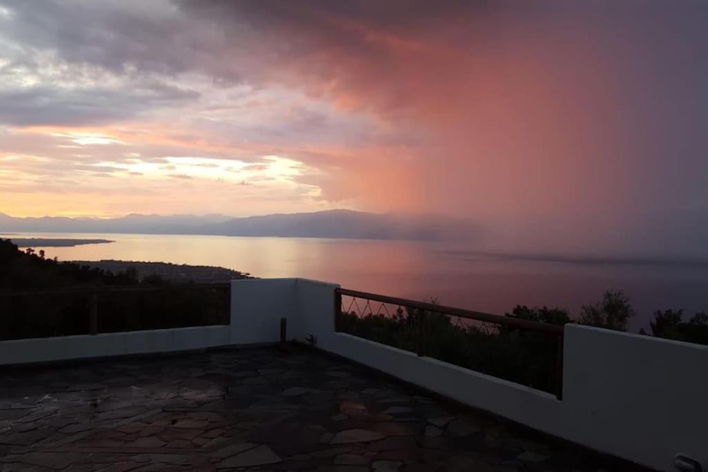 uma vista para o pôr-do-sol a partir da varanda de uma casa em Tranquility Mountain & Sea View Koudoura House em Trápeza