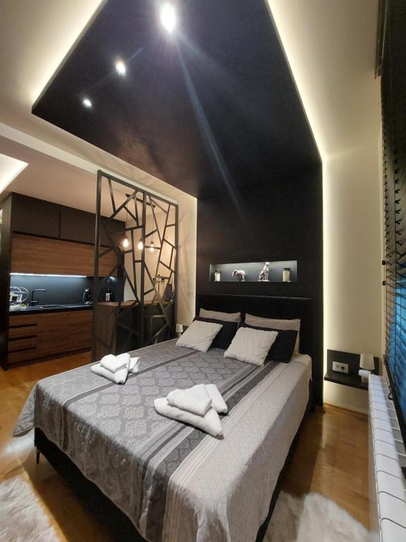 una camera da letto con un grande letto con due asciugamani di TORRO LUX Apartment a Palić