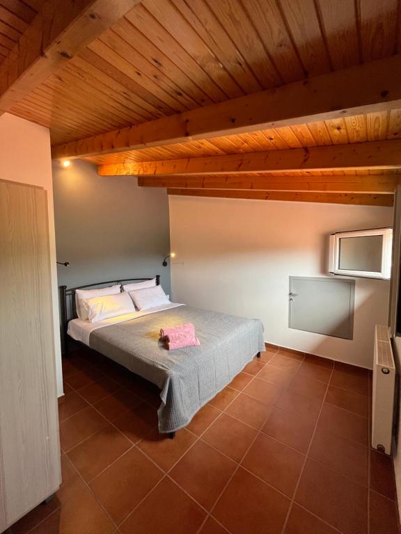 um quarto com uma cama e um tecto de madeira em Ενθύμιον em Nafplio