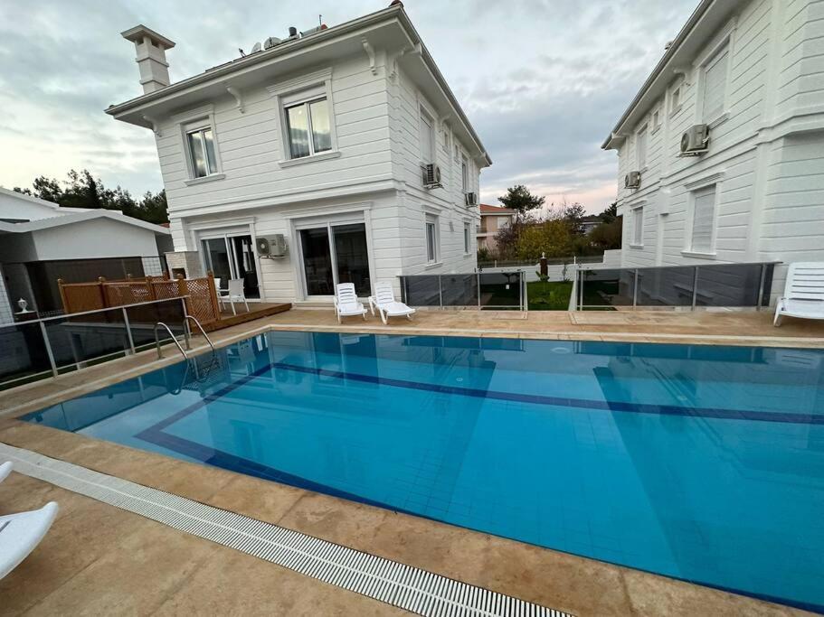 une grande piscine bleue en face d'une maison dans l'établissement Villa Dream Antalya döşemealtı, à Dosemealti