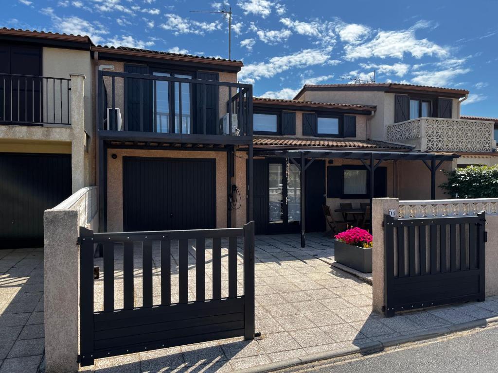 a house with two gates in front of a driveway at Portiragnes Plage PSD04 in Portiragnes