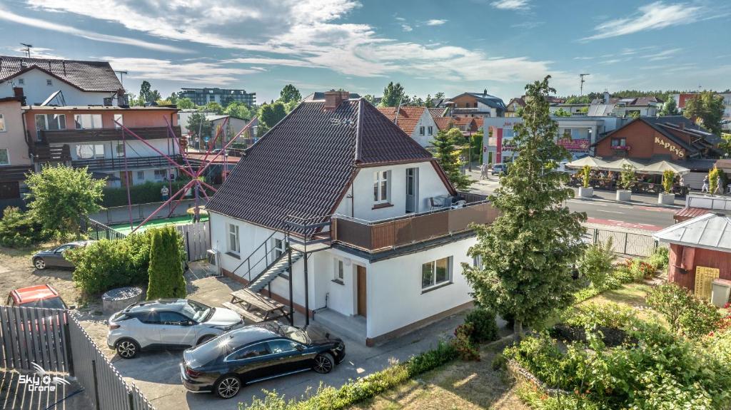 a house with a black car parked in front of it at Domek z trzema sypialniami - Dom Morsa Mielno in Mielno
