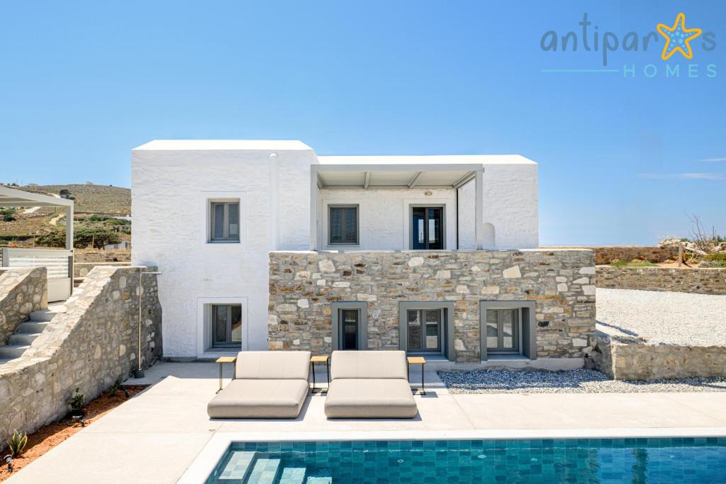 a villa with a swimming pool and a house at Antiparos Homes in Antiparos