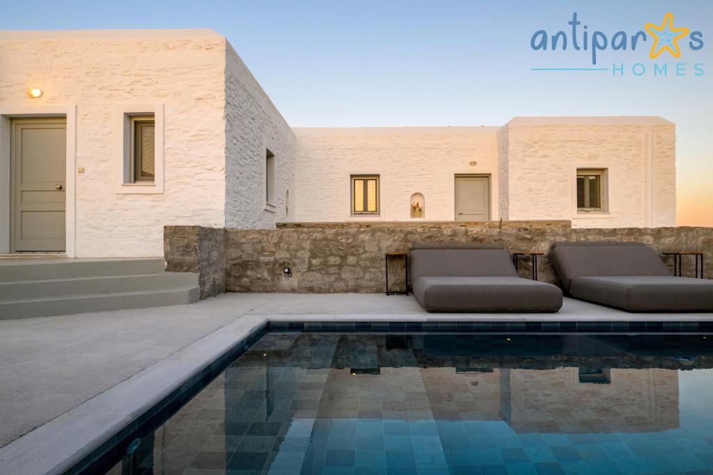 a villa with a swimming pool and a house at Antiparos Homes in Antiparos