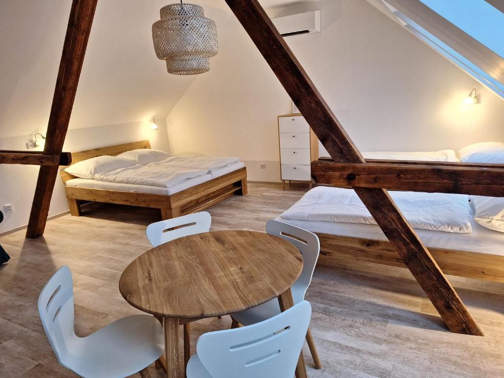 een kamer met 2 bedden en een tafel en stoelen bij Na Sedmnáctce - s vířivkou in Dolní Bojanovice