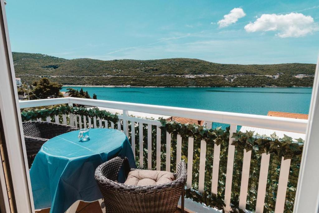 una mesa en un balcón con vistas al agua en Apartments Ivona, en Neum