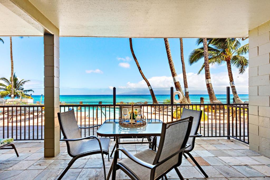 Noelani 115 في Kapalua-West Maui Airport: طاولة وكراسي على شرفة مطلة على المحيط