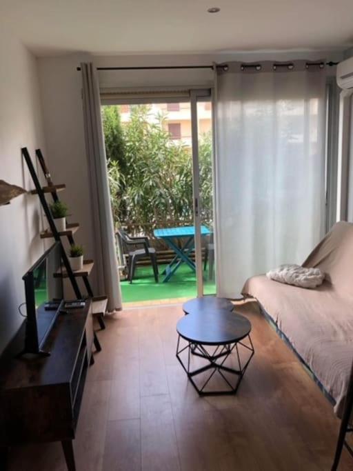 - un salon avec un lit et une table basse dans l'établissement Appartement rénové RDC terrasse 200m plage, à Port-la-Nouvelle