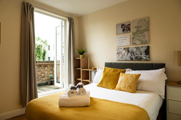 a bedroom with a large bed with two stuffed animals on it at 94b Mackenzie road in London