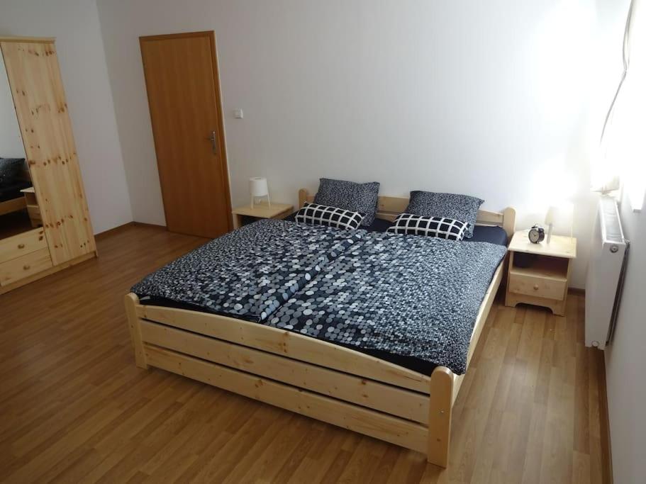 a bedroom with a bed with blue pillows on it at Luxusní apartmán v centru Božího Daru in Boží Dar