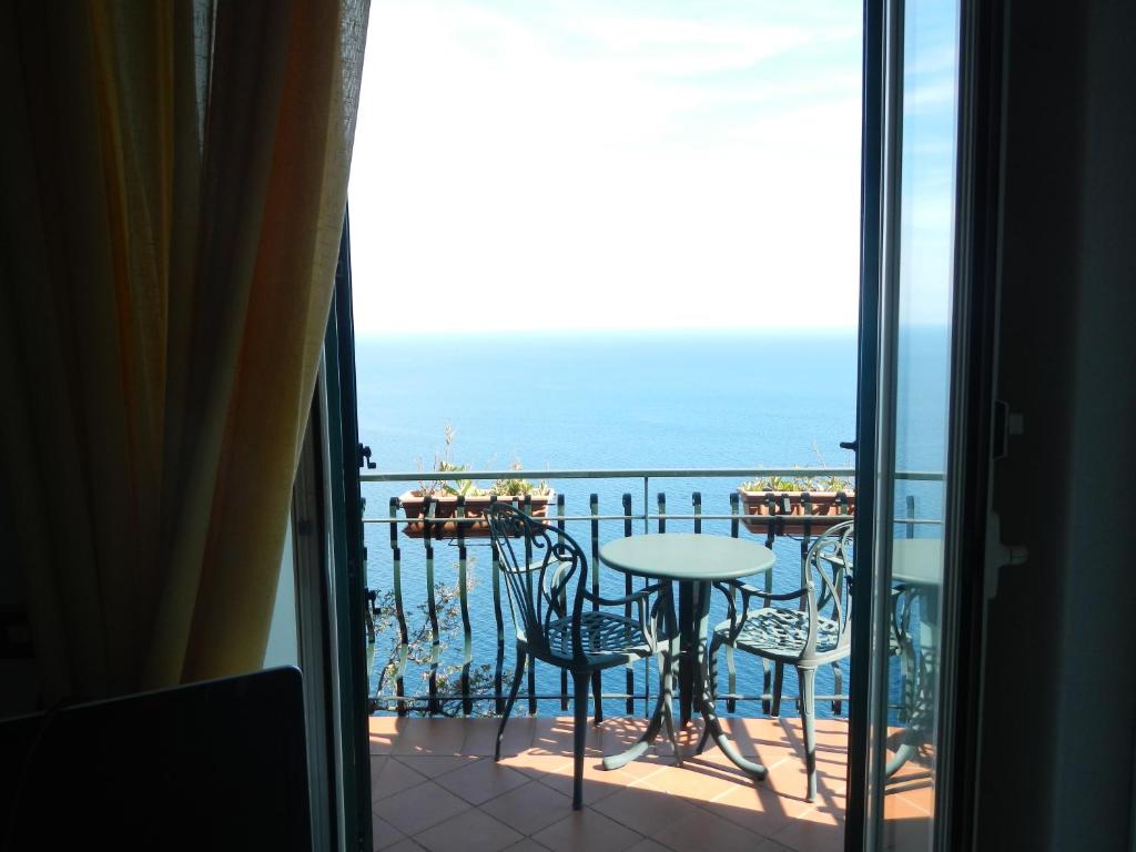einen Balkon mit einem Tisch und Stühlen sowie Meerblick in der Unterkunft Casa Bouganville in Positano