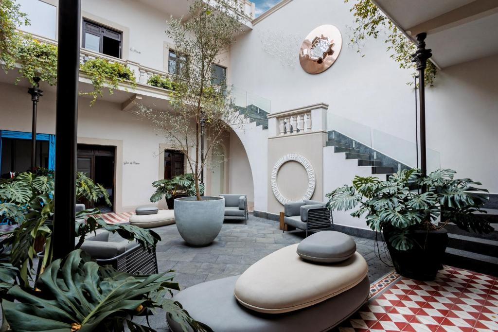 a courtyard with chairs and plants in a building at Casona 142 Orizaba, Part of Curamoria Collection in Orizaba