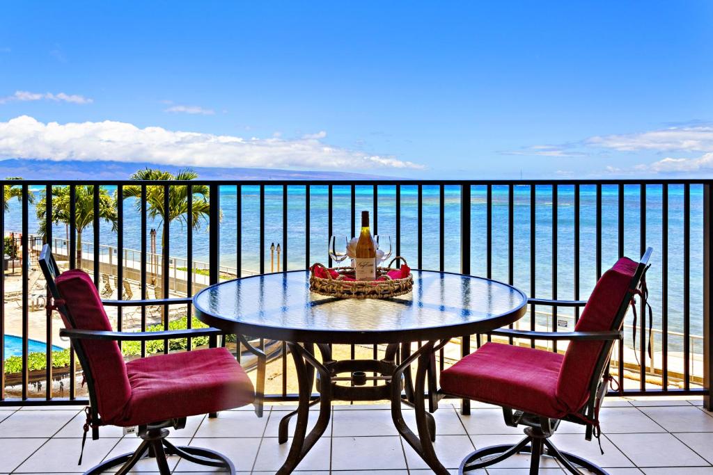a table on a balcony with a view of the ocean at Hololani A203 in Kahana