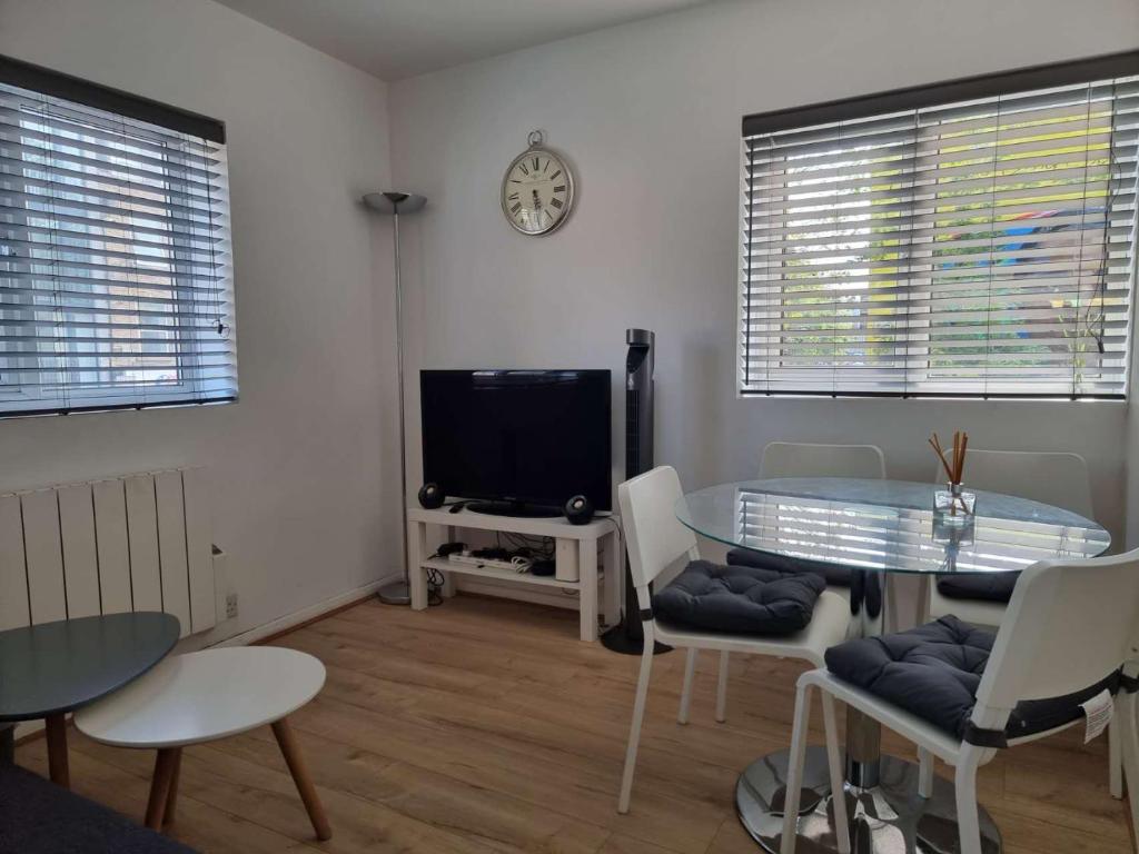 a living room with a table and a tv at Bethnal Green/Brick Lane 2 Bedroom Apartment in London