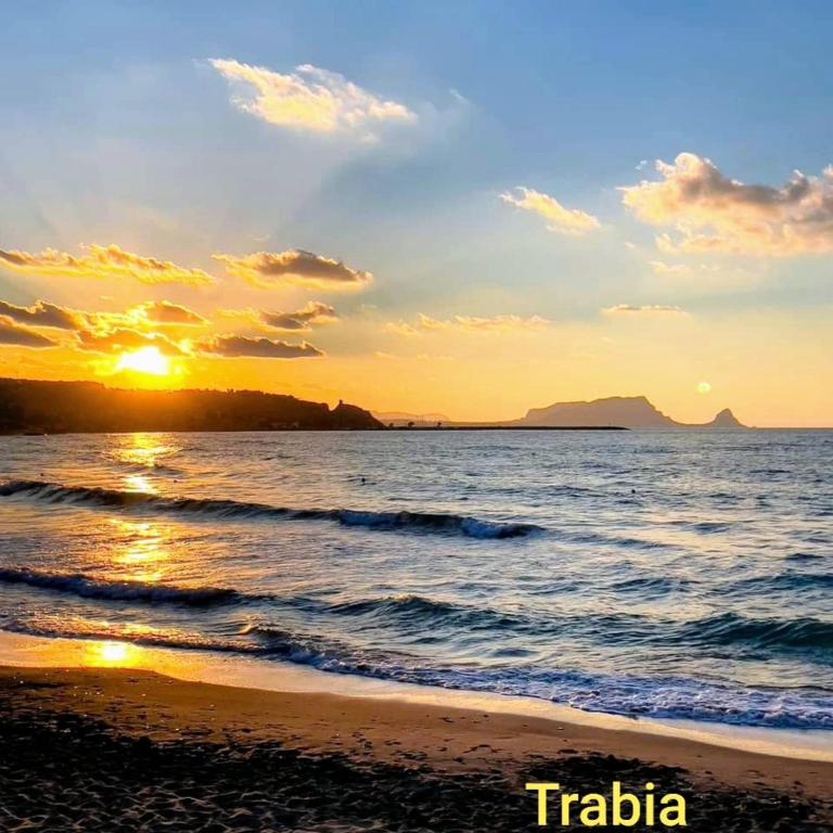 a sunset on a beach with the ocean at Domus Mea in Trabia