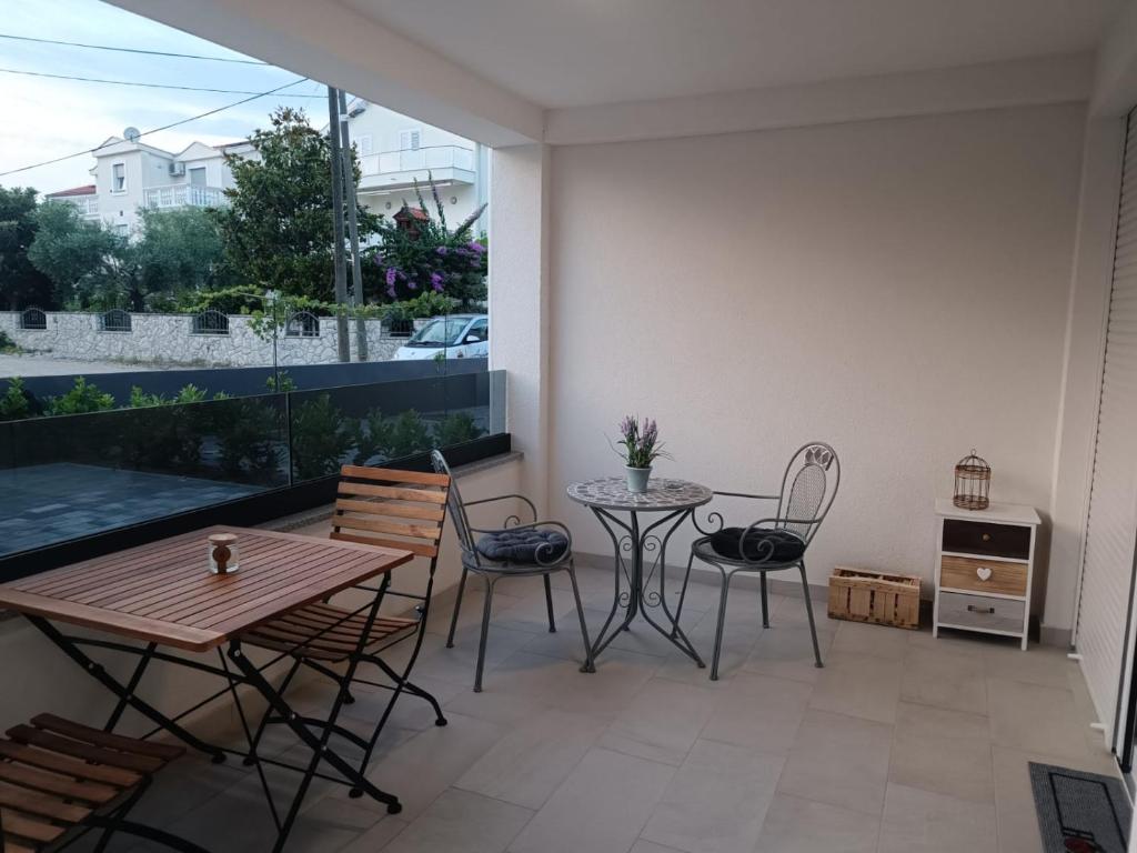 a patio with a table and chairs on a balcony at Apartman Mila in Biograd na Moru