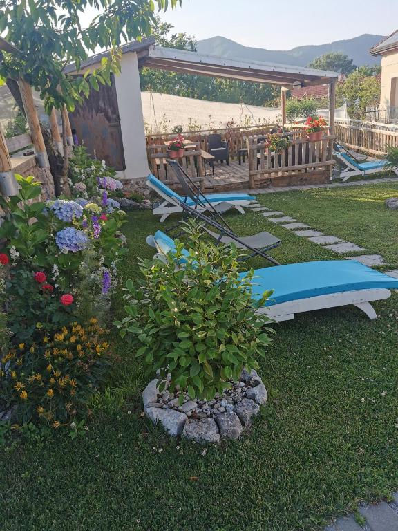 a garden with benches and a table and a surfboard at Astra in Agerola