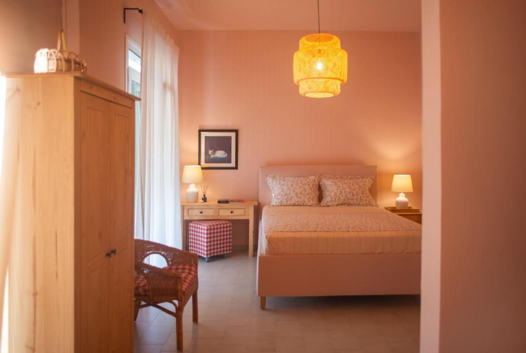 um quarto com uma cama, uma cadeira e um lustre em Nina's apartment em Lixouri