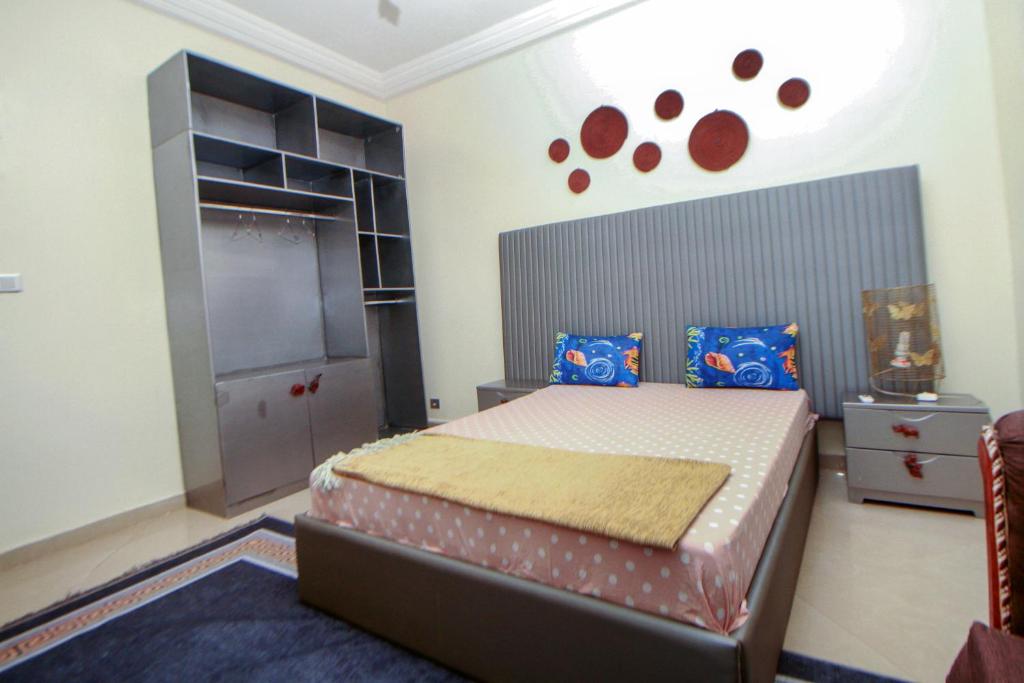 a bedroom with a large bed with a large headboard at Le "Grand Bleu", un bel appartement paisible, sûr et spatieux au cœur de la station balnéaire de Saly Portudal in Saly Portudal