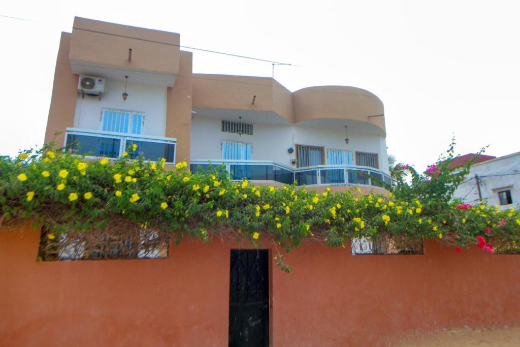 a building with flowers on the top of it at "Ô soleil" une Villa moderne dans un quartier paisible du centre de Saly in Saly Portudal