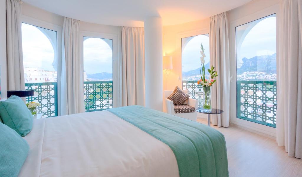 sypialnia z łóżkiem oraz balkon z oknami w obiekcie Al Mandari Hôtel Tétouan w mieście Tetuan