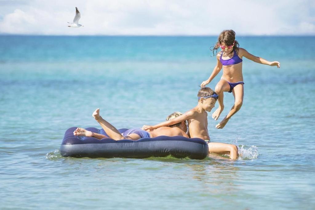 two girls playing on an inner tube in the water at Diamond Beach Residence Hotel in Durrës