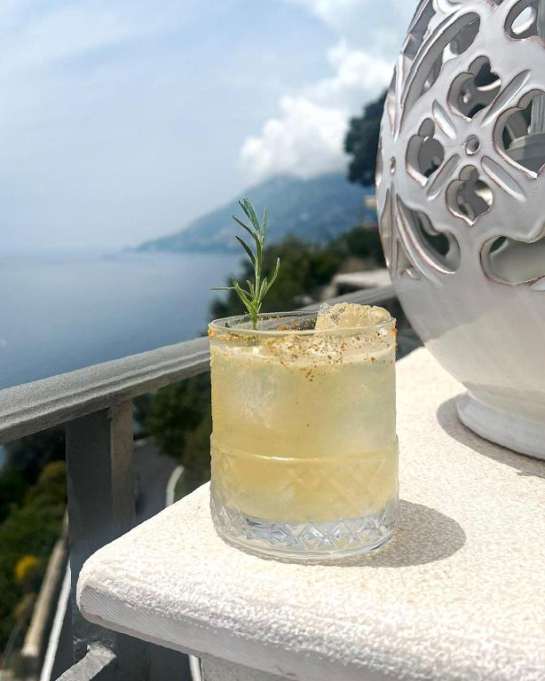 a drink sitting on a ledge with a view of the ocean at Hotel Villa Pandora in Maiori