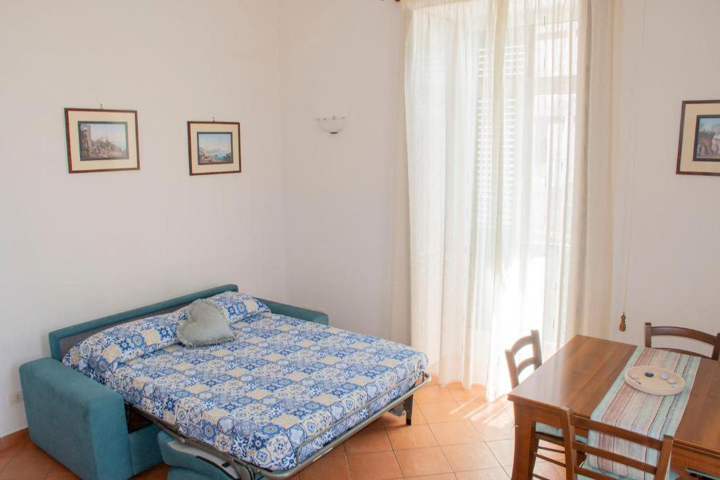 una camera con letto blu, tavolo e sedie di Casa Vacanze Uno sguardo sul mare a Maiori