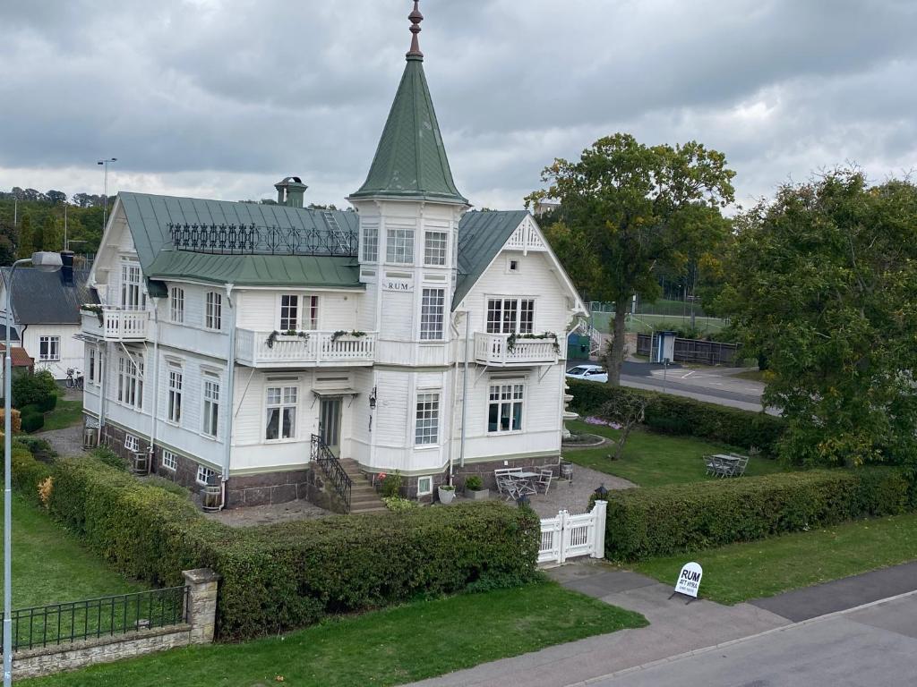 a large white house with a green roof at Villa Blenda in Borgholm