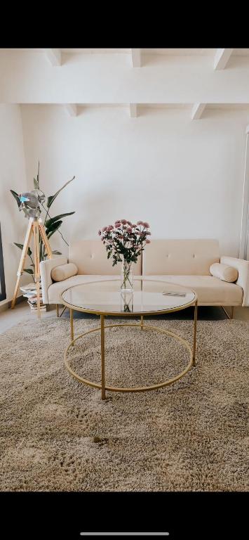 a living room with a table with a vase of flowers at Apartamento Barcelona in Barcelona