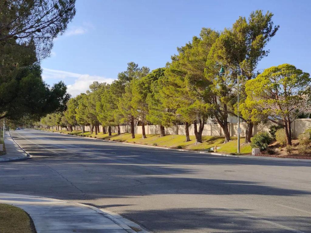 une rue vide avec des arbres sur le côté de la route dans l'établissement Nice Private Room Near Red Rock & Las Vegas Strip, à Las Vegas