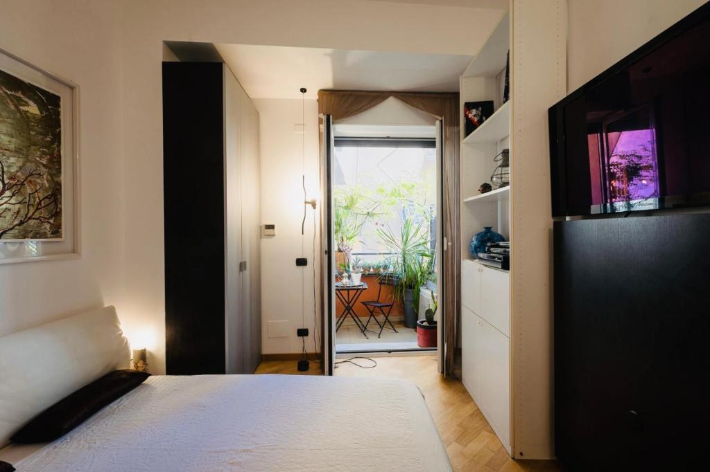 Schlafzimmer mit einem Bett und einer Tür zu einer Terrasse in der Unterkunft Nervi residenziale a due passi dal mare in Genua