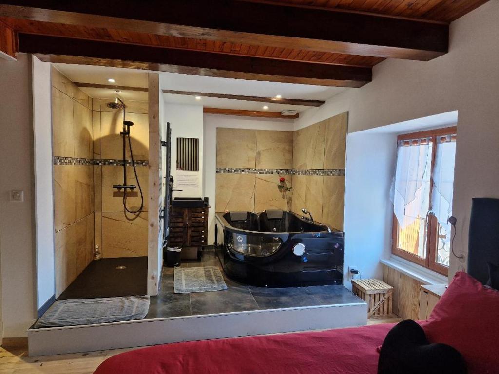 un ampio bagno con vasca in una stanza di La parenthèse coquine a Saurier