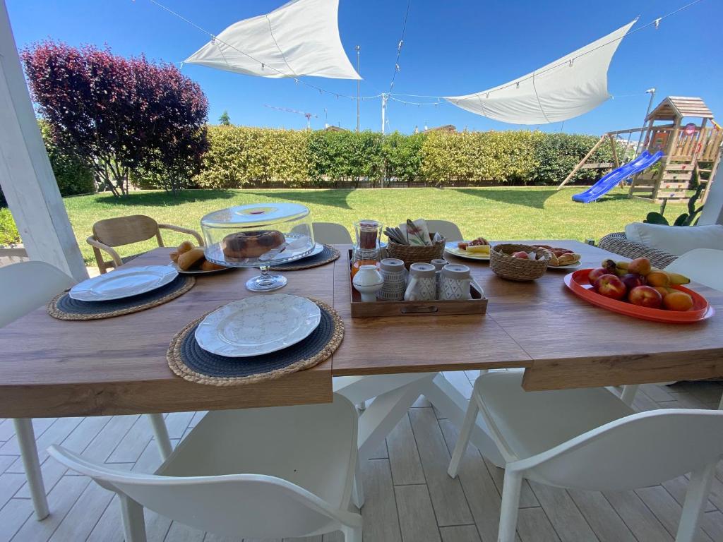 una mesa de madera con comida en la parte superior de un patio en APulia casa e cucina, en Trani