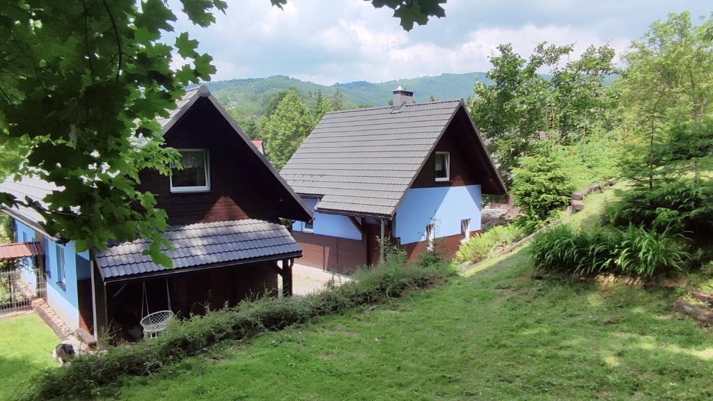 una casa con techo de gambrel en una colina en Iskierkówka, en Brenna