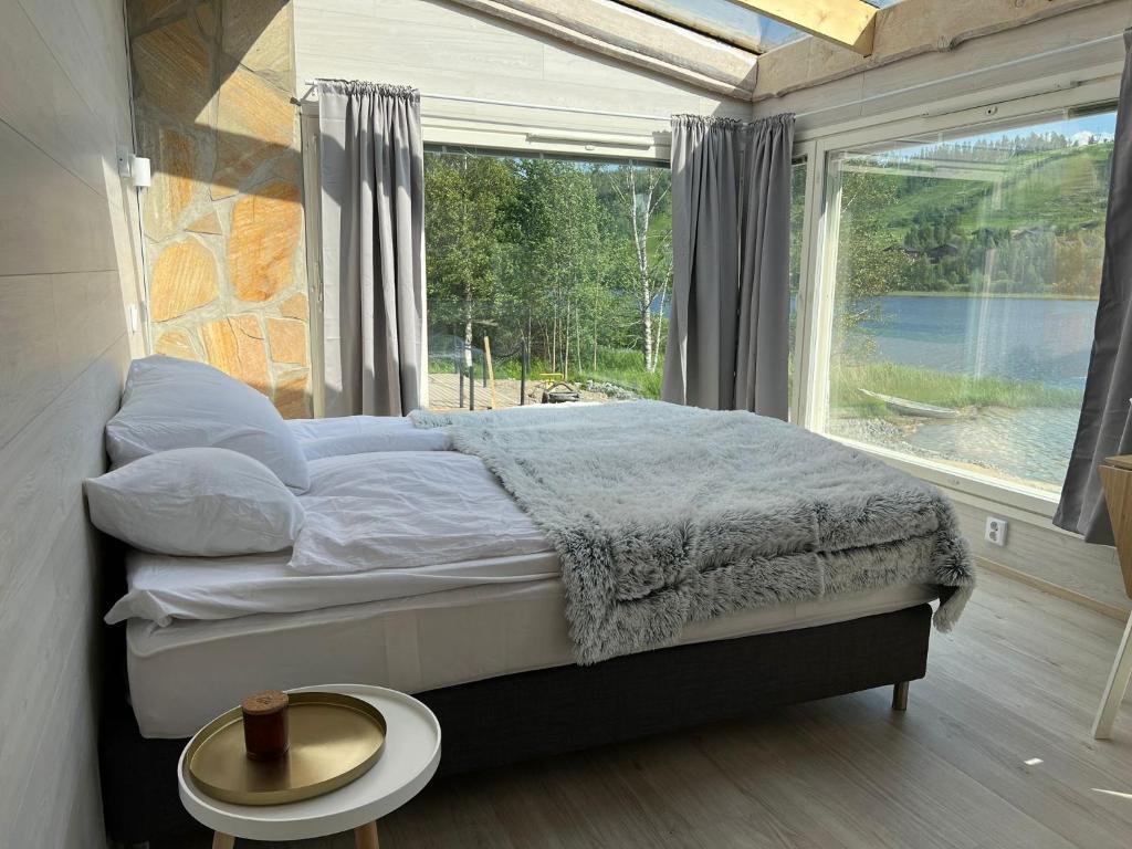 a bedroom with a bed and a large window at Himosranta Suite with sauna in Jämsä