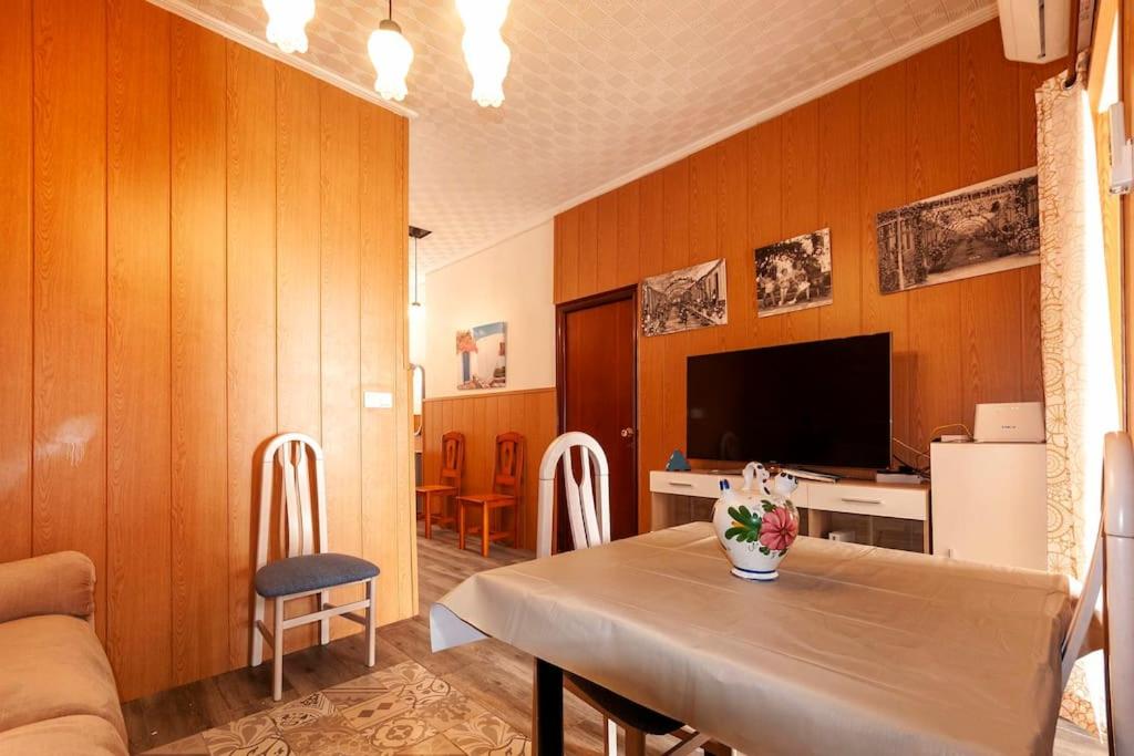 uma sala de estar com uma mesa e uma televisão em The little house in the neighbourhood em Alicante