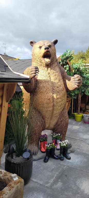 una gran estatua de un oso sosteniendo un frisbee en Fiddlers Cottage en Kesh
