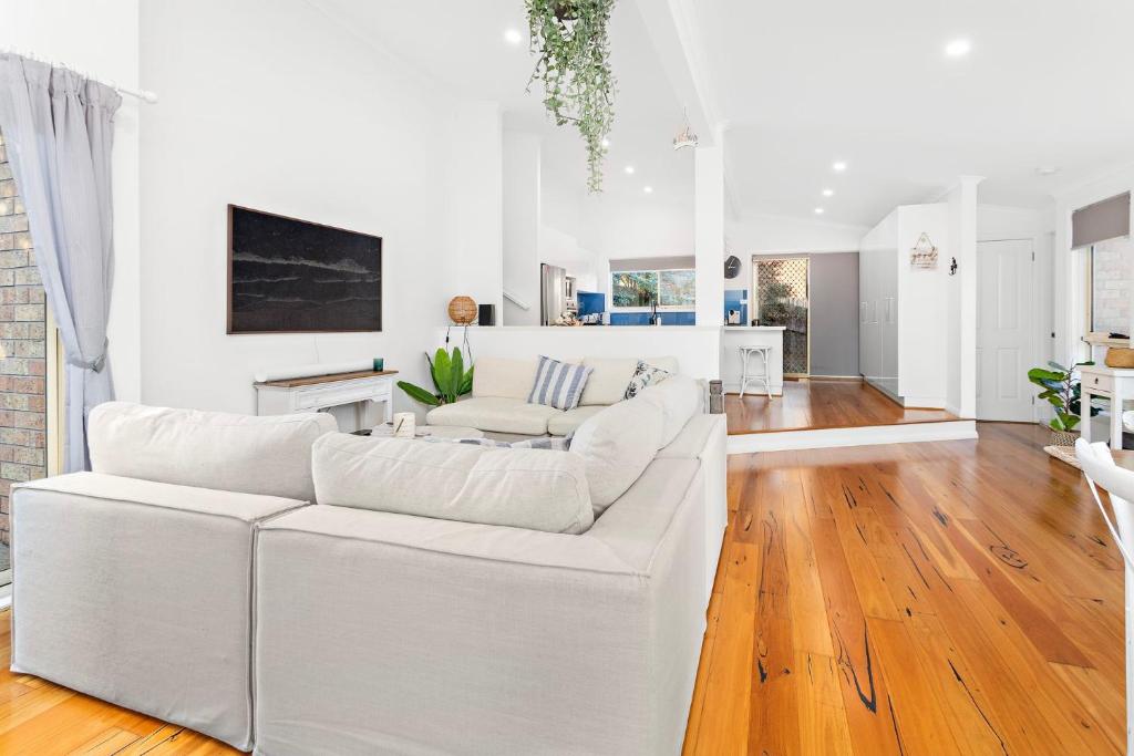 a white living room with a white couch at La Casa Bella in Gerringong