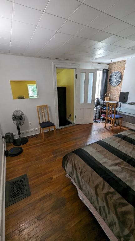 a bedroom with a bed and a wooden floor at Historic Row House in Elmira