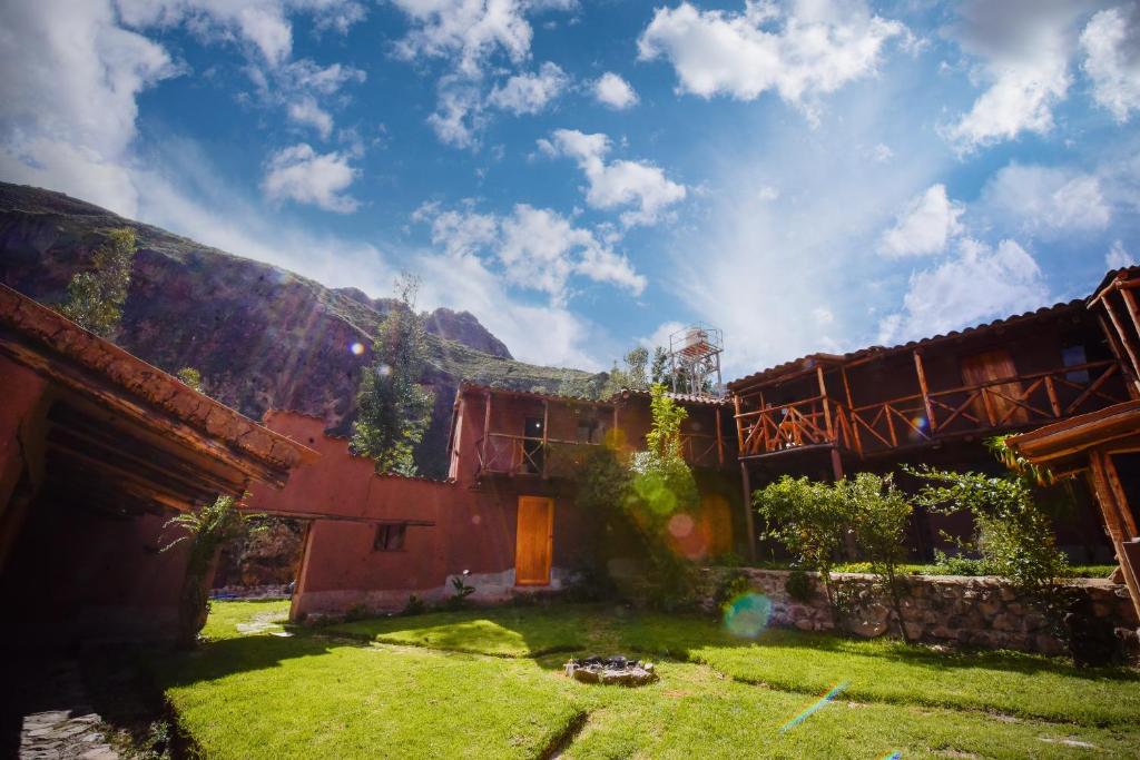 a house with a grass yard in front of it at Rumi Lodge Pisac in Pisac