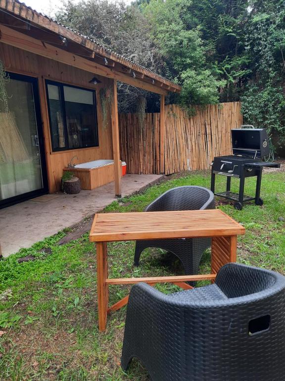 a picnic table and chairs in a backyard with a grill at PINAMARTE in Pinamar
