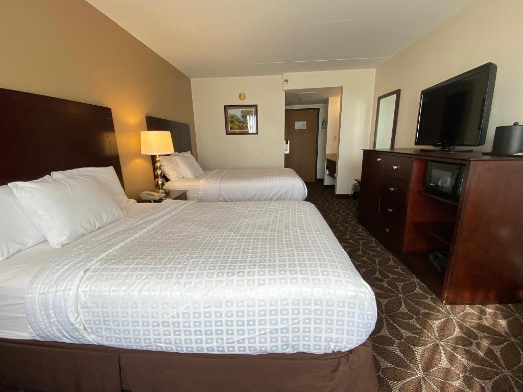 a hotel room with two beds and a flat screen tv at Wyndham Garden Williamsburg Busch Gardens Area in Williamsburg