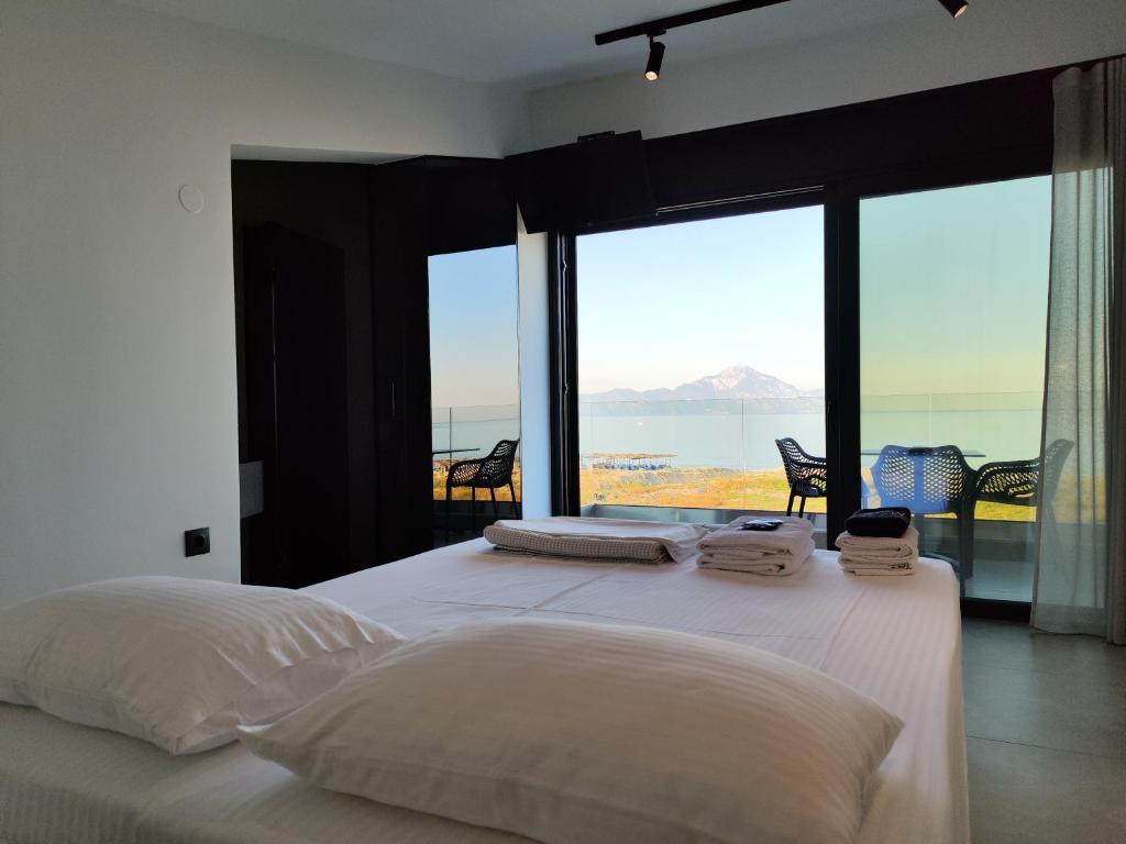 a bedroom with a bed with a view of the ocean at Onar in Sarti in Sarti